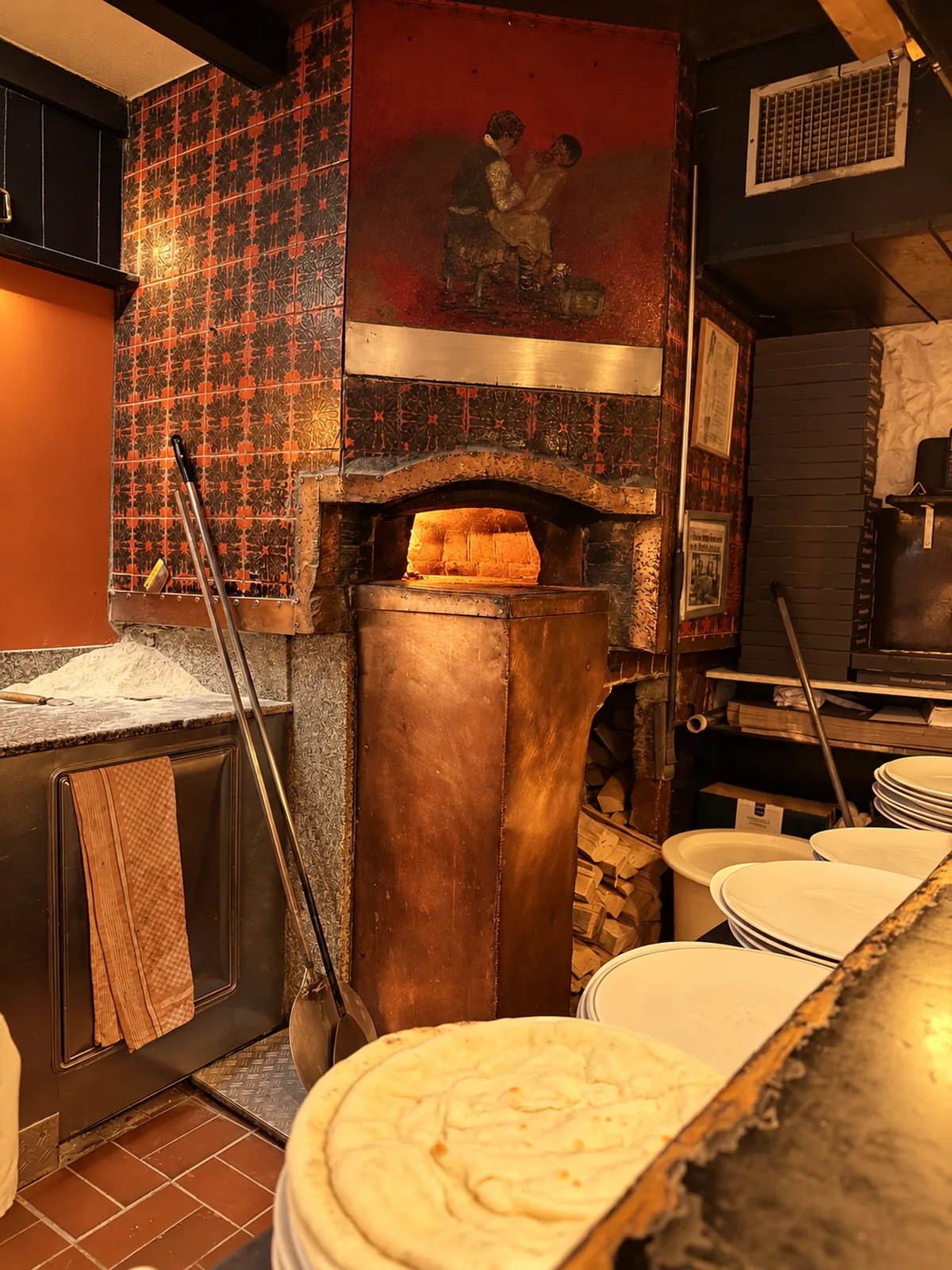 Der mit Buchenholz geheizte Steinofen der Pizzeria Pinocchio, davor frischer Pizzateig