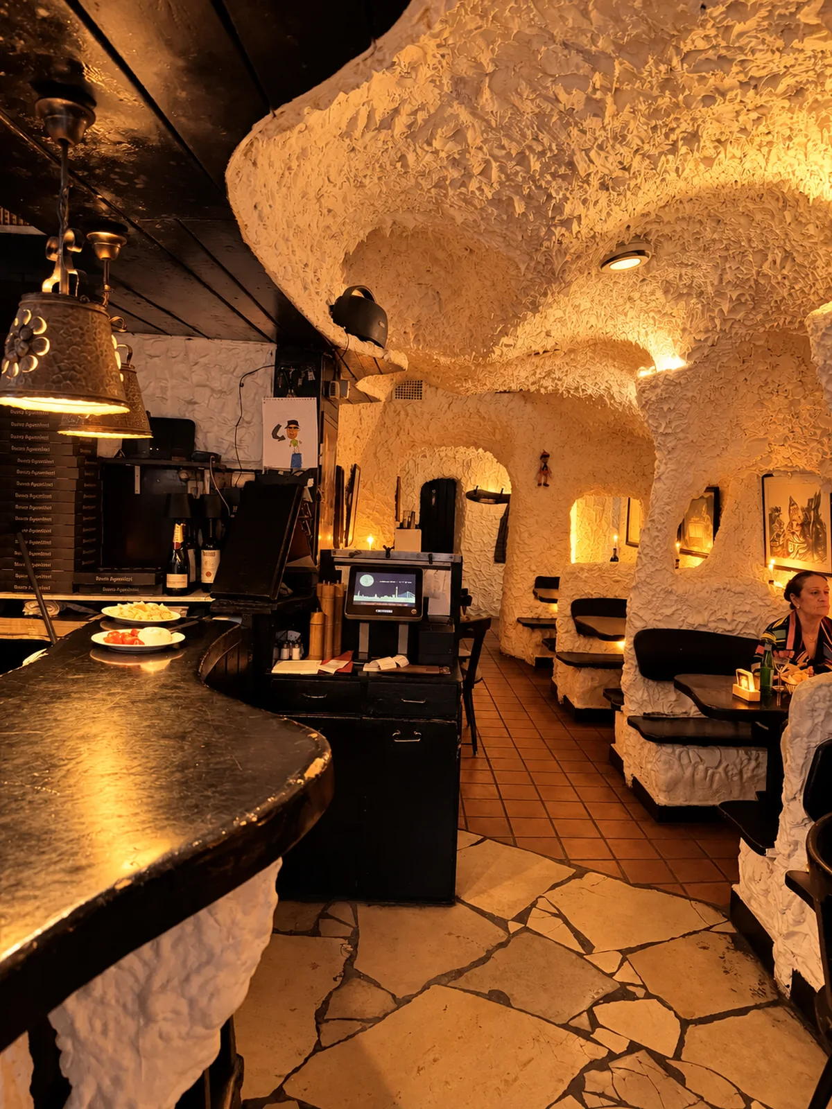 Der Gastraum der Pizzeria Pinocchio wie eine Grotte mit weißen Stuckwänden